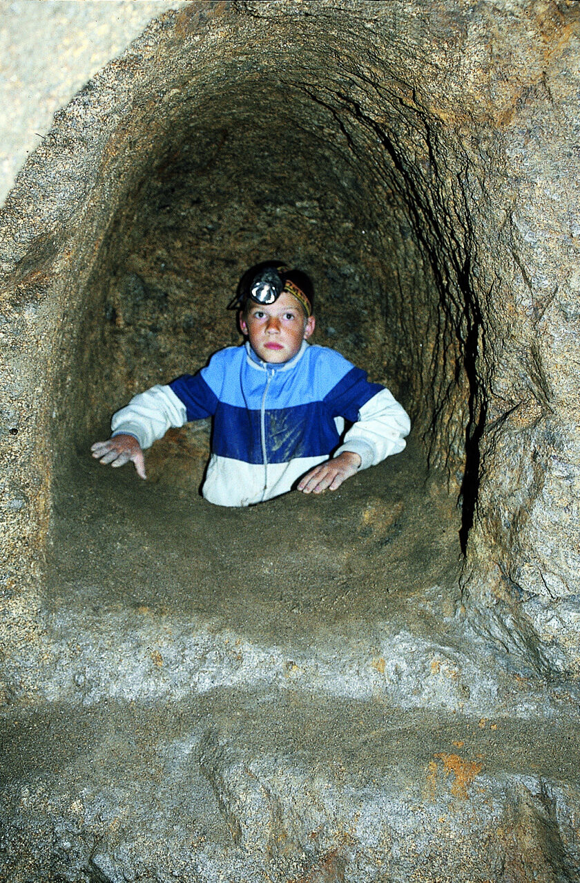 A narrow vertical slip-passage, or Schlupf, cut through rock between two levels of an Erdstall tunnel system