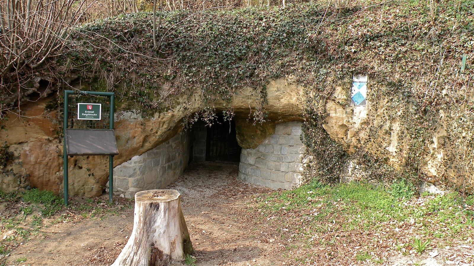 The low, dark entrance to the Ratgöbluckn Erdstall at Perg in Upper Austria, set into a rock face
