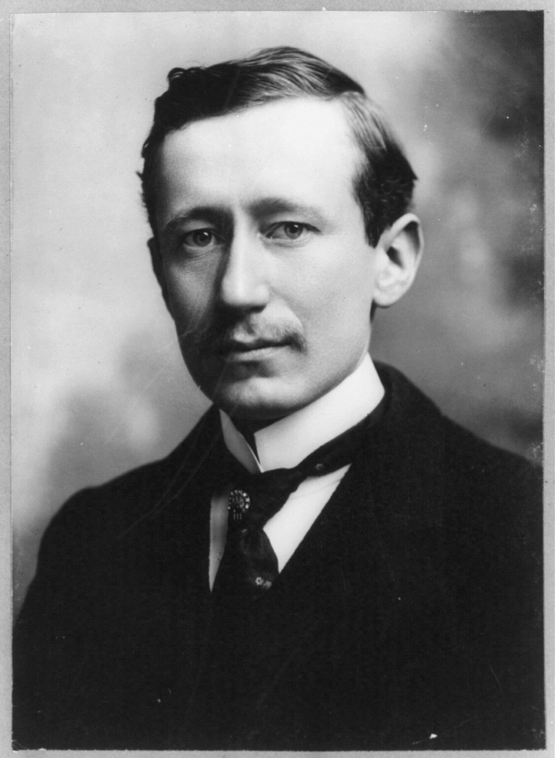 Studio portrait photograph of Guglielmo Marconi in a dark suit, seated and facing the camera